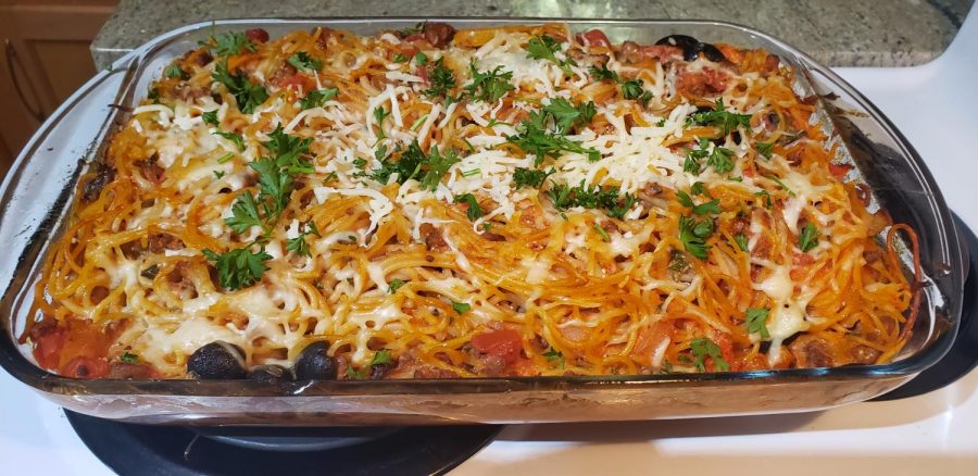 Baked spaghetti topped with mozzarella cheese and parsley.