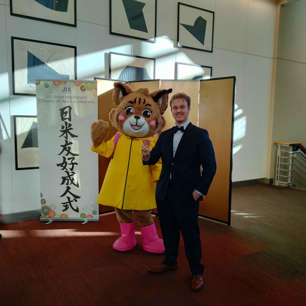 Xander Siqveland (Ebbtide staff writer) standing next to Belle the Bobcat, Bellevue's Yuru-Chara, at the event's reception. The term Yuru-chara refers to mascot characters with cute aesthetics used for promotional purposes.