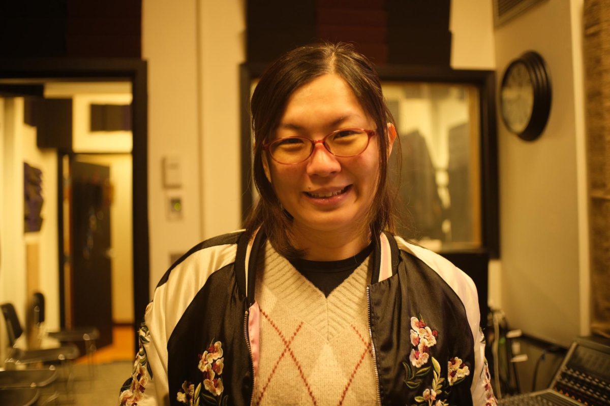 Jisa Kang, Audio Specialist at Shoreline College, smiles while preparing equipment in the 800 Music Building. She is helping organize the building’s farewell celebration on Nov. 21, honoring decades of student performances and memories.