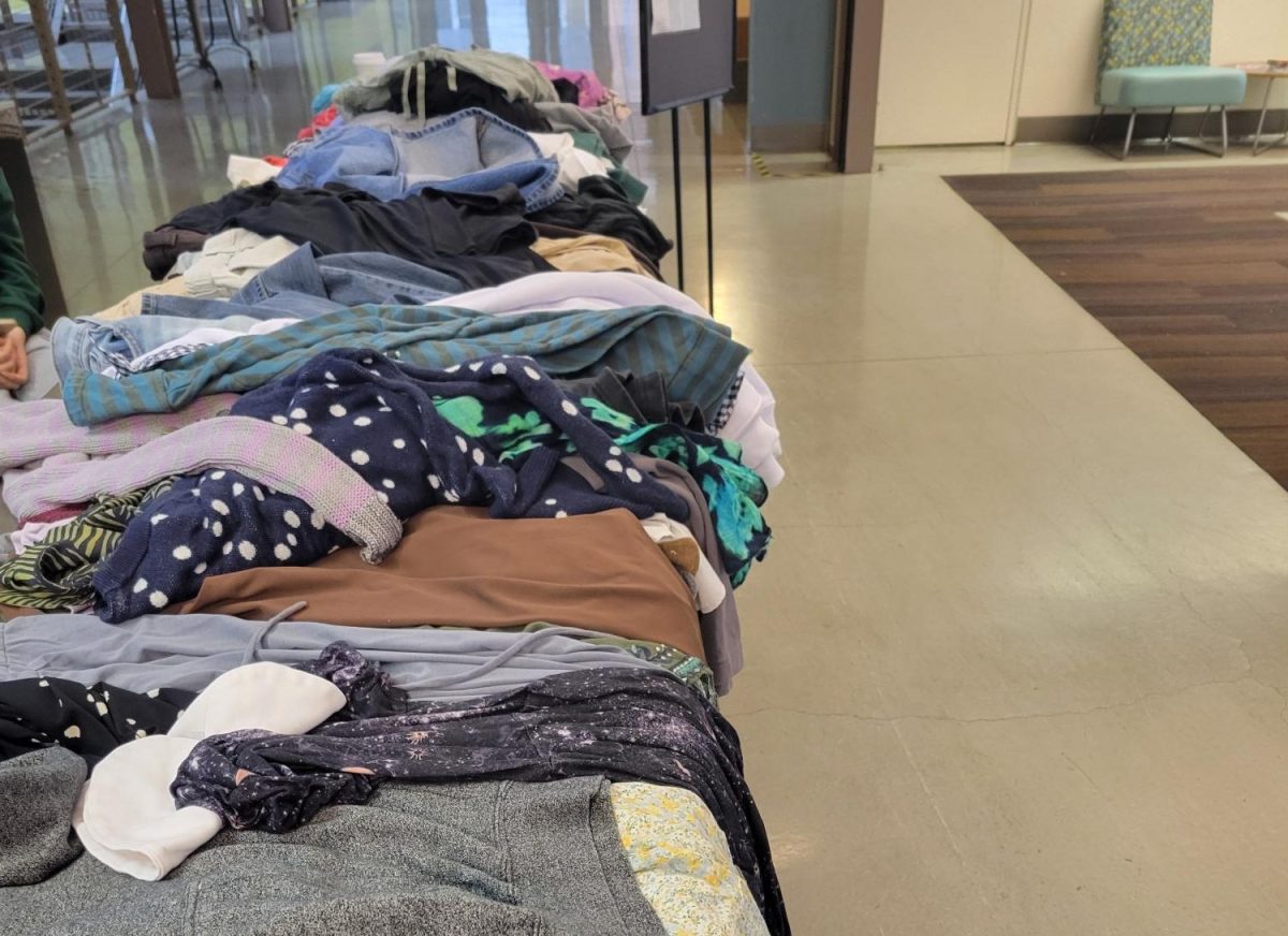 A table in the PUB lobby is piled with donated clothes for the clothing swap. Clothing swaps like these can prevent clothes from going into the landfill.