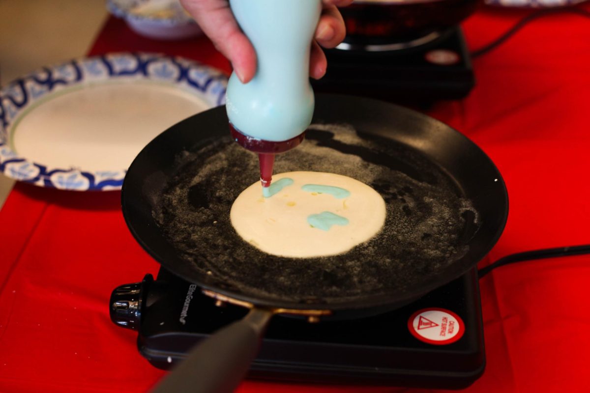 A student puts a smile on their pancake.