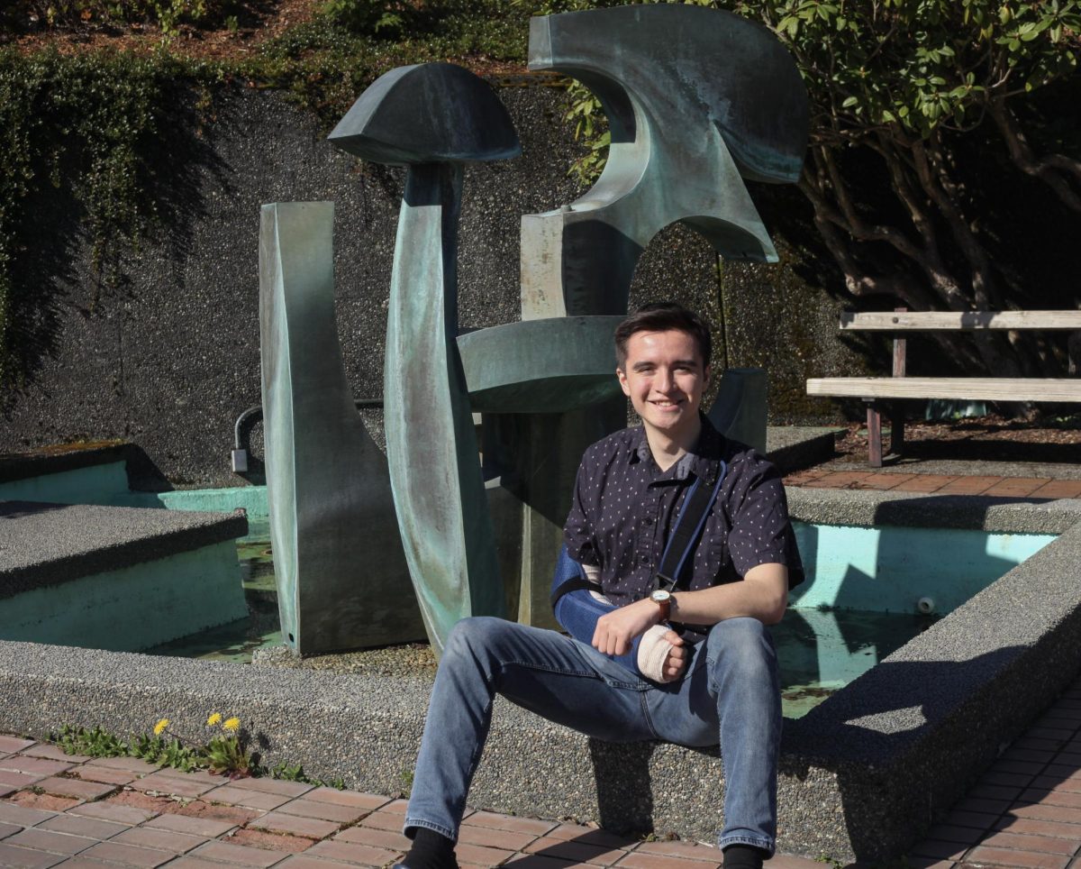 Lucas Heber, President of the Progressive Political Action Club sits on the fountain in front of the PUB.